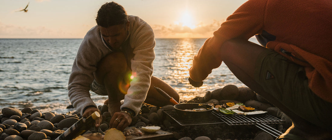 Two people cooking on the beach