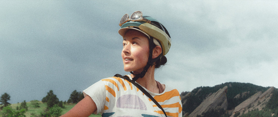 A woman in a bike helmet in front of a mountain range