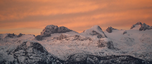 A snowy mountain landscape at sunrise